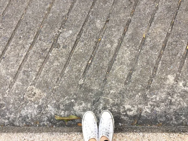 Ungt mode kvinnans ben med Sneakers, vita skor på golvet bakgrund — Stockfoto