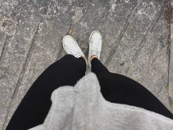 Junge Mode Frauenbeine mit Turnschuhen, weiße Schuhe auf Bodengrund — Stockfoto