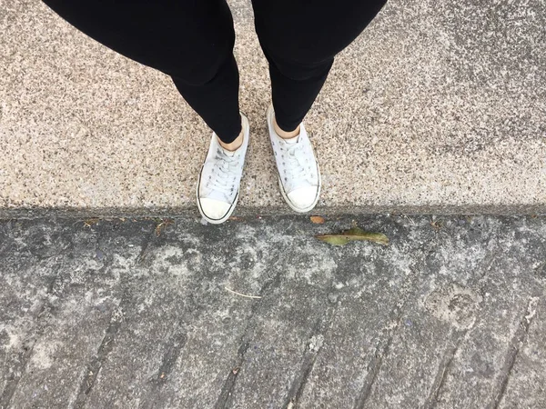 Jeune Mode Femmes Jambes avec Sneakers, Chaussures blanches sur fond de sol — Photo