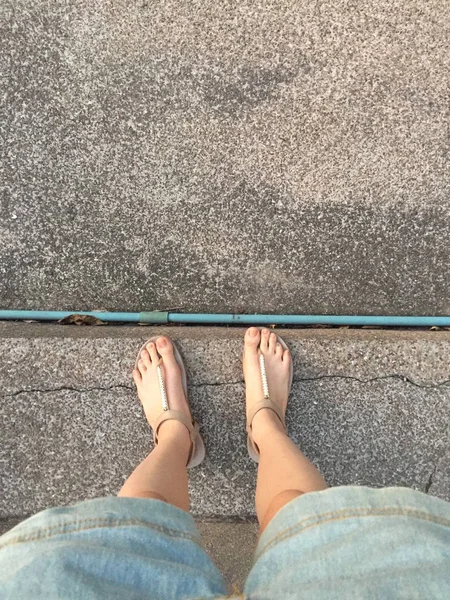 Junge Mädchen Beine in goldenen Sandalen auf Treppe Hintergrund — Stockfoto