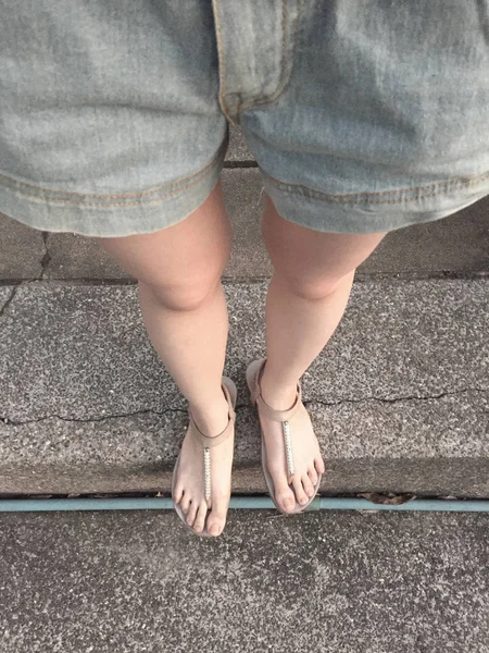 Ung flicka ben i guld sandaler på trappa bakgrund — Stockfoto