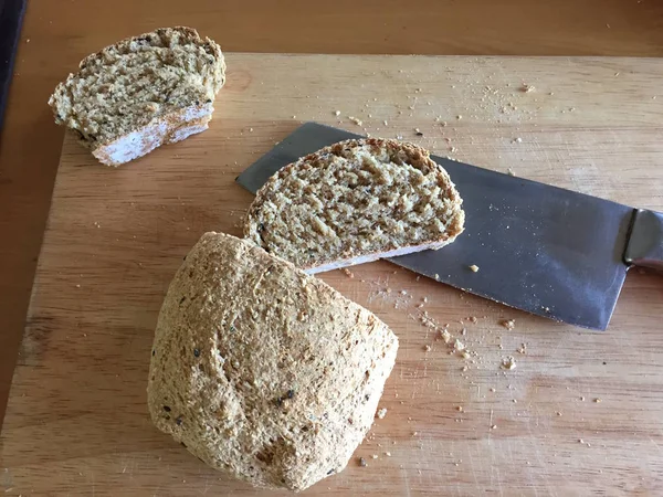 Frisches Brot Scheibe und Schneidmesser auf Tisch hölzernen Hintergrund — Stockfoto