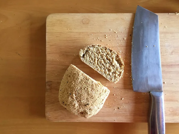 Frisches Brot Scheibe und Schneidmesser auf Tisch hölzernen Hintergrund — Stockfoto