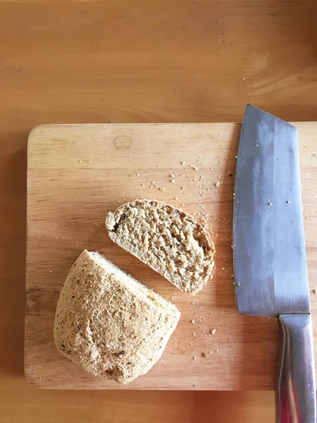 Świeży chleb kawałek i nóż do cięcia na stole drewniane tło — Zdjęcie stockowe