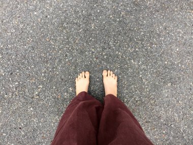 Kadının Lay pantolon ve taş zemin zemin üzerinde çıplak ayak