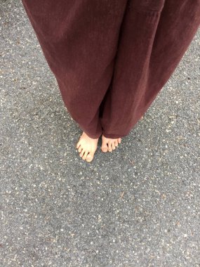 Kadının Lay pantolon ve taş zemin zemin üzerinde çıplak ayak