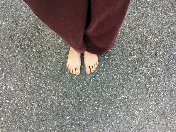 Woman`s Lay pants and Bare Feet on Stone Ground Background — Stock Photo, Image