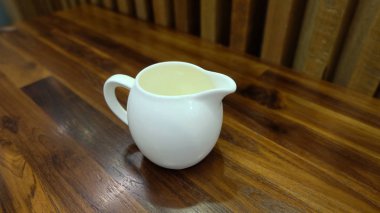 Sürahi (atıcı) ahşap arka plan üzerinde taze süt 