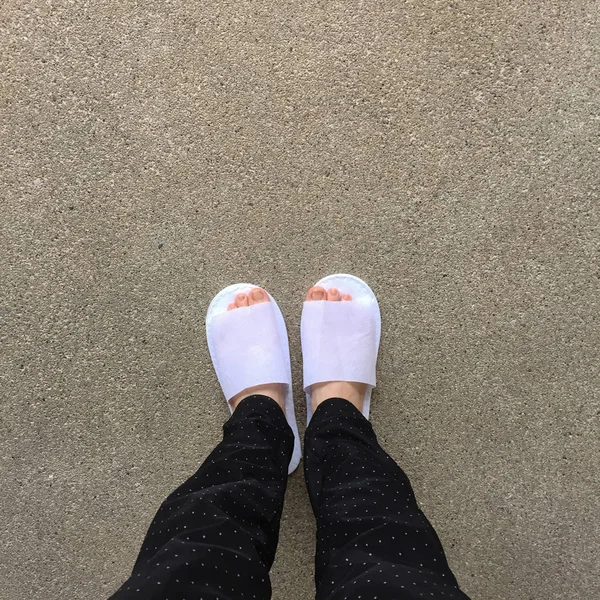 Femme portant des chaussons blancs debout sur le fond du sol — Photo