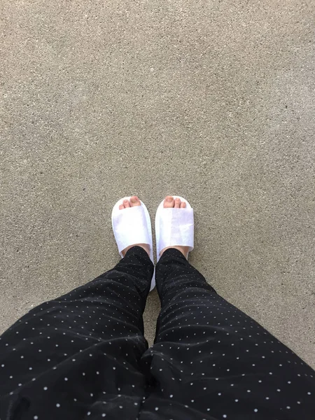 Femme portant des chaussons blancs debout sur le fond du sol — Photo