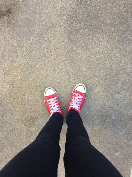 Feet From Above Concept, Teenage Person in Red Sneakers Standing on Ground Background — Stock Photo, Image