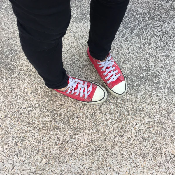 Pies desde arriba Concepto, Persona adolescente en zapatillas rojas de pie en el fondo del suelo —  Fotos de Stock
