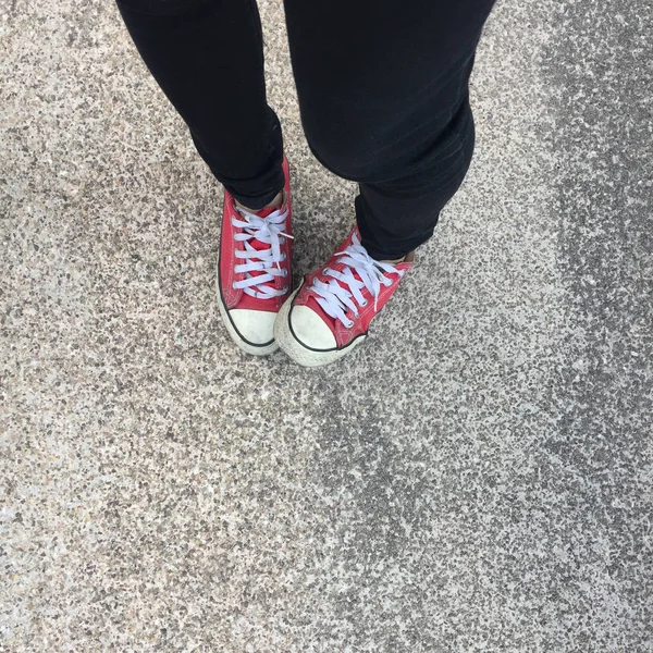 Pés de cima do conceito, pessoa adolescente em tênis vermelho em pé no fundo do solo — Fotografia de Stock