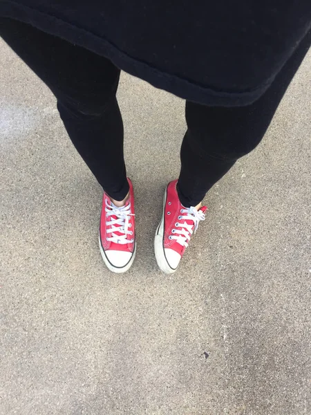 Láb felülről koncepció, tizenéves, aki állandó a talaj háttér piros cipők — Stock Fotó