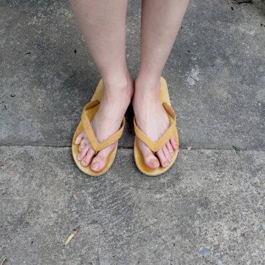 Toprak zemin üzerine kadın ayakları üzerinde sarı sandal