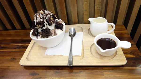 Postre de hielo de nieve cubierto con chocolate y salsa dulce, un tazón de postre de hielo Bingsu en la mesa de madera —  Fotos de Stock