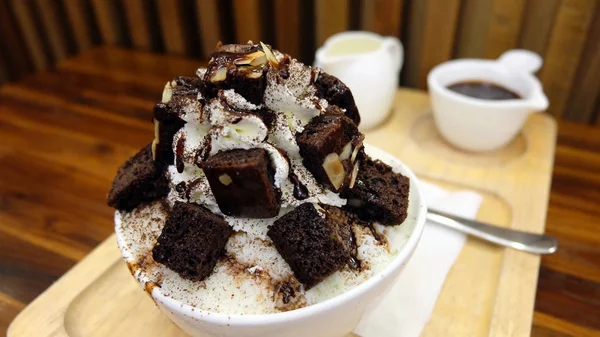 Snow Ice Flake Dessert Topping con cioccolato e salsa dolce, una ciotola di Bingsu Ice Dessert sulla tavola di legno — Foto Stock