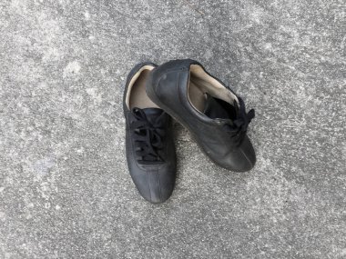 Beton zemin zemin üzerine eski siyah ayakkabı 