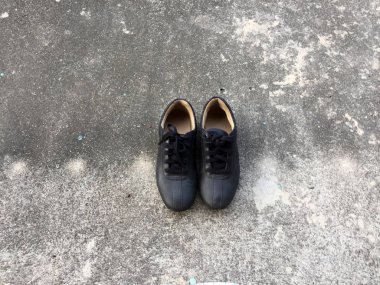 Beton zemin zemin üzerine eski siyah ayakkabı 