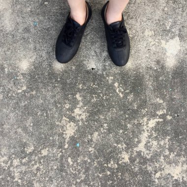 Beton zemin üzerinde duran siyah ayakkabı