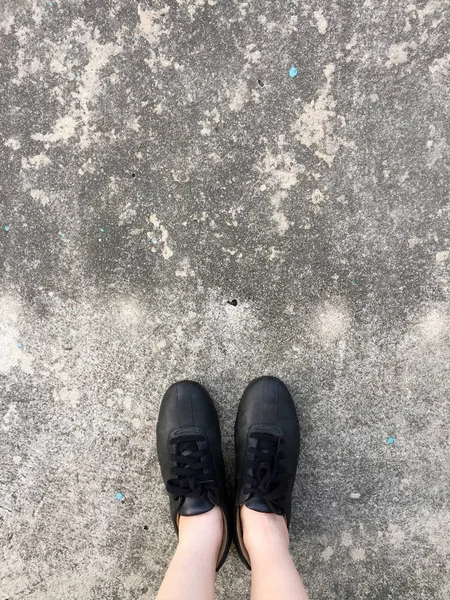 Chaussures noires debout sur le sol en béton — Photo