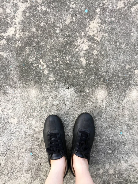 Sapatos pretos de pé no chão de concreto — Fotografia de Stock