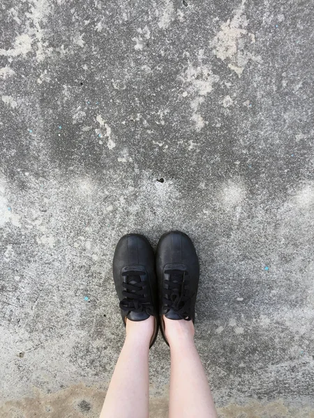 Schwarze Schuhe stehen auf dem Betonboden — Stockfoto