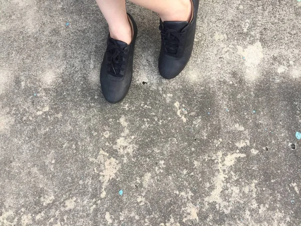 Zapatos negros de pie en el suelo de hormigón — Foto de Stock