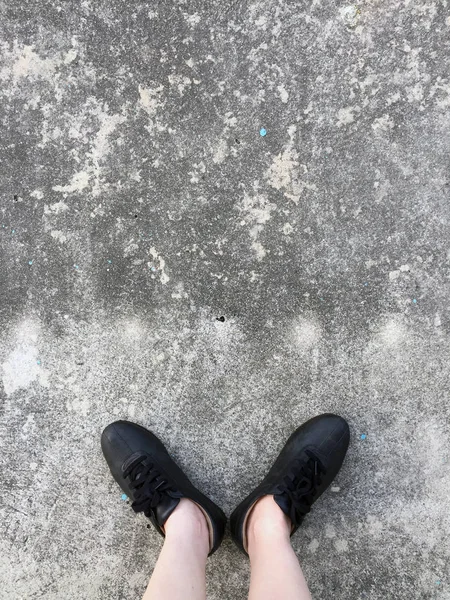 Черные ботинки, стоящие на бетонном полу — стоковое фото