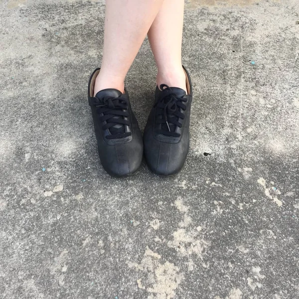 콘크리트 바닥에 서 있는 검은 신발 — 스톡 사진