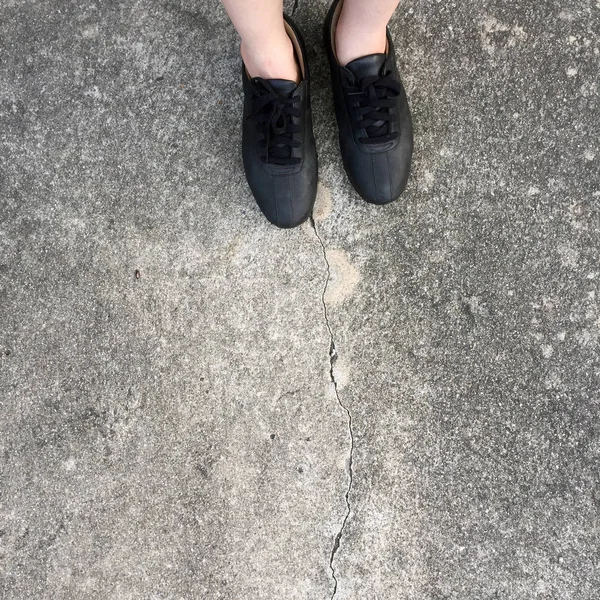 Czarne buty stoi na betonowej podłodze — Zdjęcie stockowe