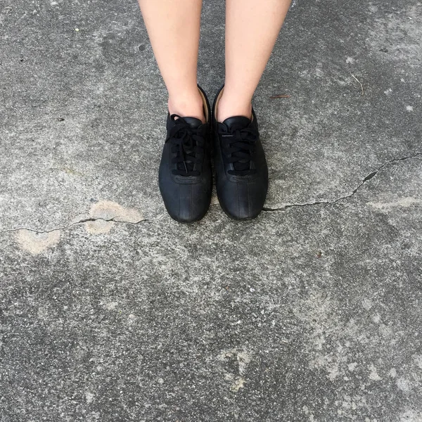Chaussures noires debout sur le sol en béton — Photo