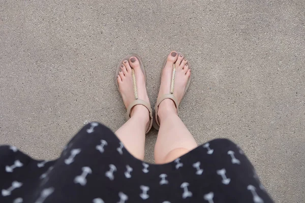 Selfie pieds portant des sandales en or et robe sur fond de sol — Photo