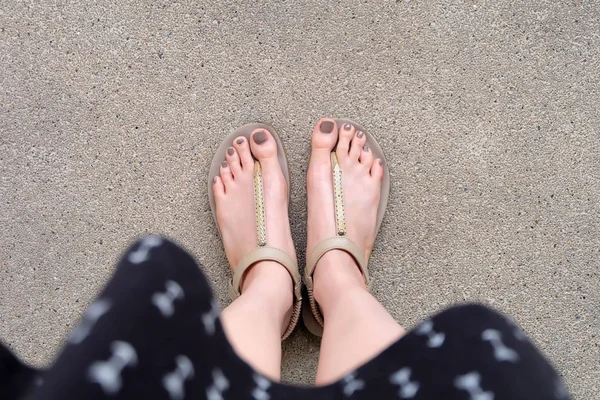 Selfie pés vestindo sandálias de ouro e vestido no fundo do solo — Fotografia de Stock