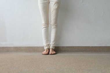 Kadın ayakları yere, açık arka plan altın Sandaletler içinde
