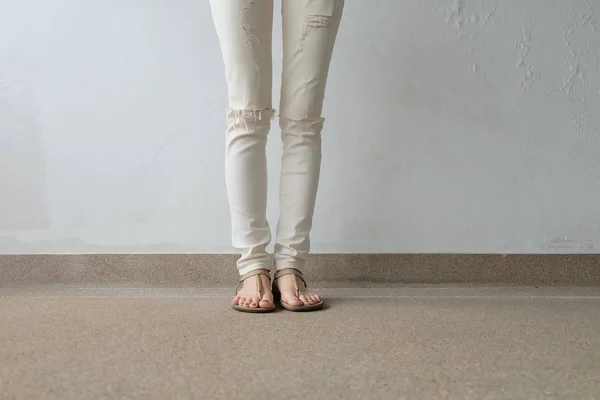 Nő lábát a földön, szabadtéri háttér aranyszínű szandál — Stock Fotó