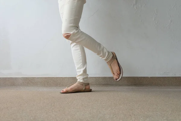 Женские ноги в золотых сандалиях на земле, на открытом воздухе — стоковое фото