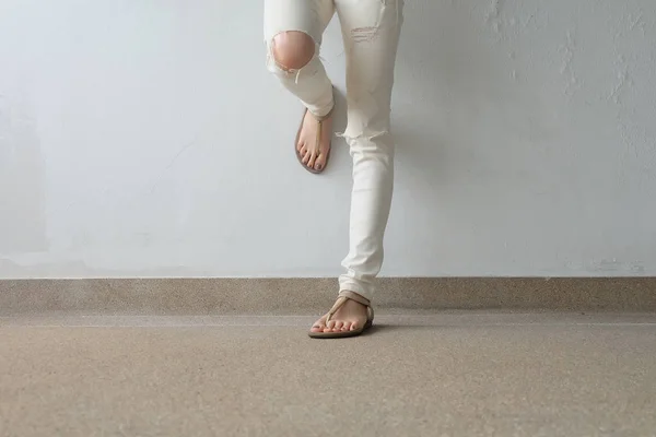 Kobieta nogi w złote sandały na ziemi, odkryty tło — Zdjęcie stockowe