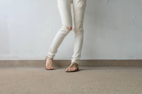 De benen van de vrouw in gouden sandalen op grond, buiten achtergrond. — Stockfoto