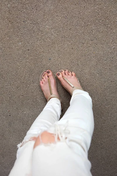 Selfie Pés vestindo sandálias de ouro e calça branca no fundo do chão — Fotografia de Stock