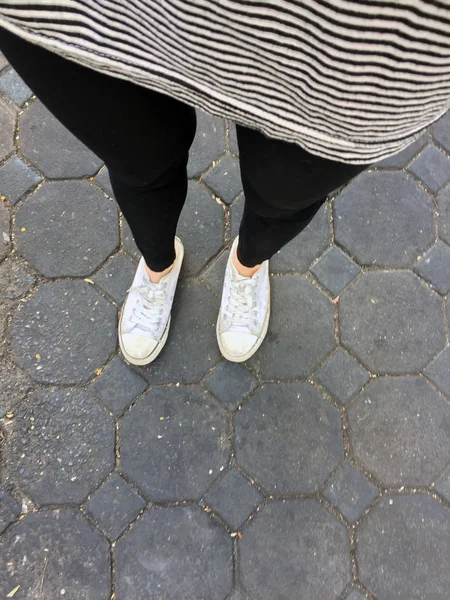 Foto di primo piano della donna che indossa scarpe da ginnastica bianche in strada — Foto Stock