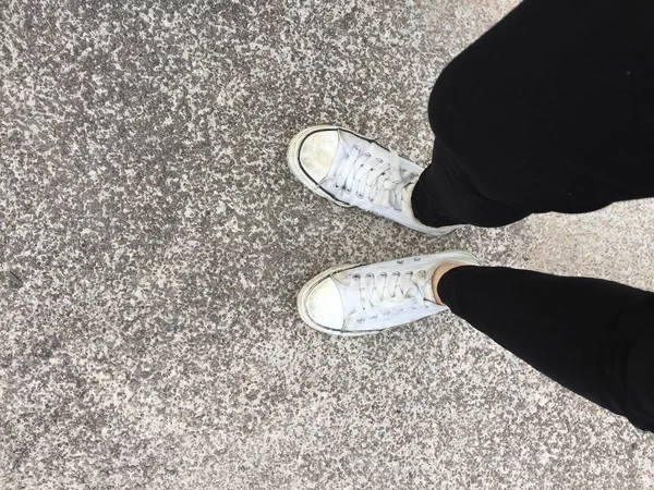 Nahaufnahme von einer Frau, die weiße Turnschuhe auf der Straße trägt — Stockfoto