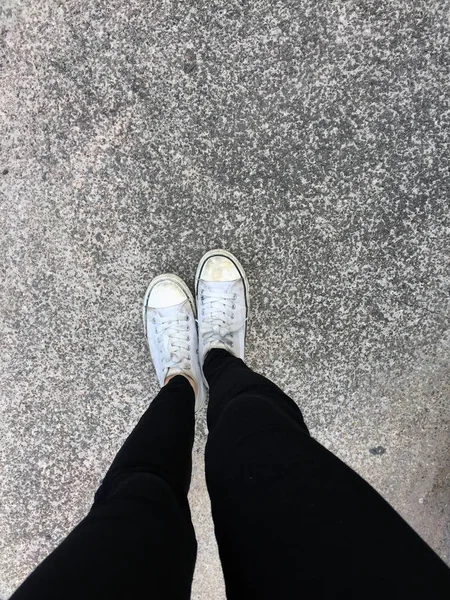 Foto de primer plano de la mujer que usa zapatillas blancas en la calle —  Fotos de Stock