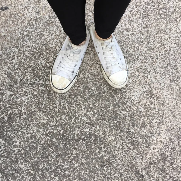 Foto de primer plano de la mujer que usa zapatillas blancas en la calle — Foto de Stock