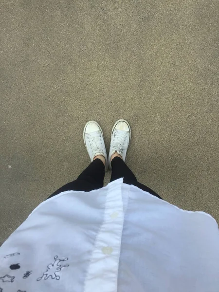 Nahaufnahme von einer Frau, die weiße Turnschuhe auf der Straße trägt — Stockfoto
