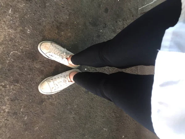 Foto de primer plano de la mujer que usa zapatillas blancas en la calle — Foto de Stock