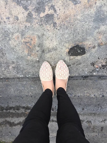 Close Up Of Girl 's Feet Wearing Sandals In The Ground — стоковое фото