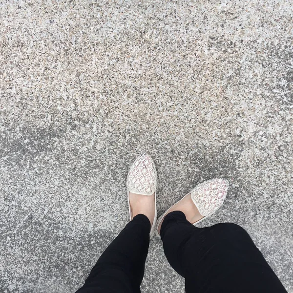 Primer plano de los pies de la muchacha que usa sandalias de tejido en el suelo —  Fotos de Stock