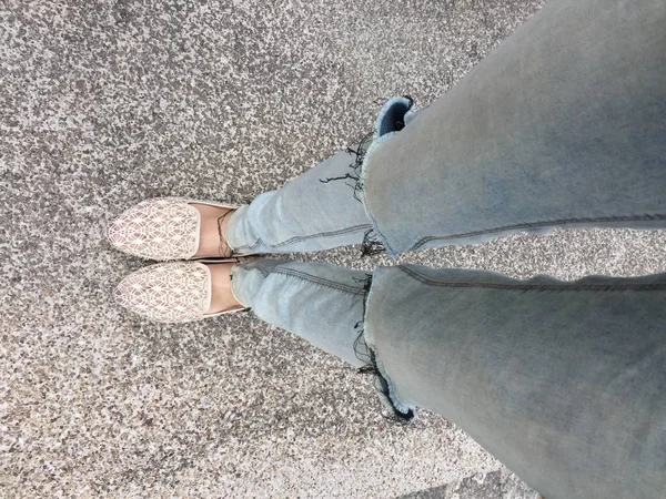 Primer plano de los pies de la muchacha que usa sandalias de tejido en el suelo — Foto de Stock