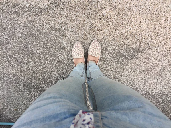Close Up di piedi della ragazza che indossa sandali tessitura nel terreno — Foto Stock